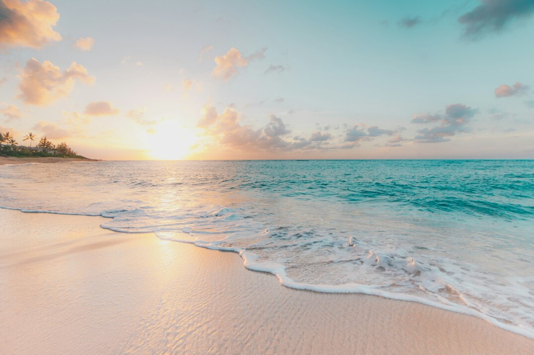 Wide sandy beach and sea at sunset